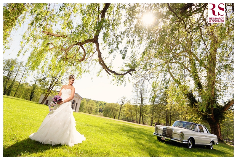 Braut auf Hochzeitsfoto mit Mercedes Oldtimer im Schloßpark