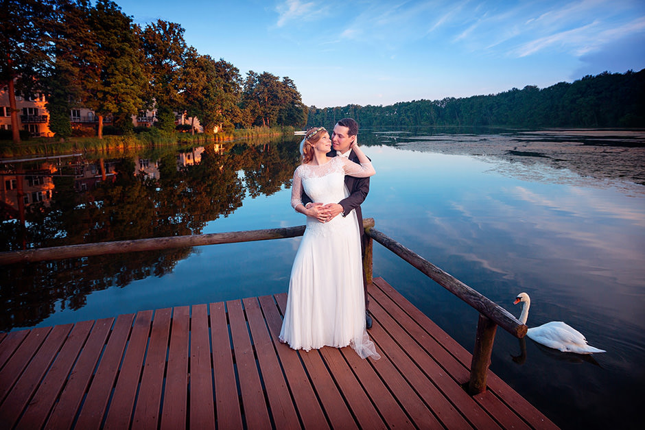 Hochzeitspaar am See mit einem Schwan im Wasser
