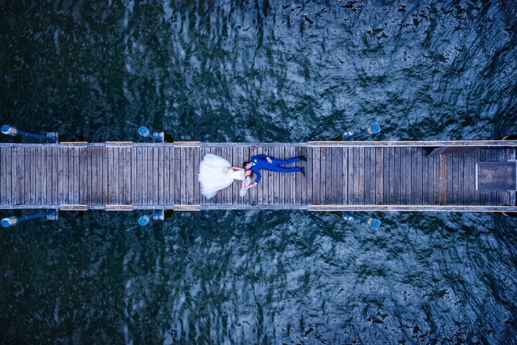 Hochzeitsfoto in Neuruppin mit Drohne fotografiertes Brautpaar auf Steg zum Ruppiner See