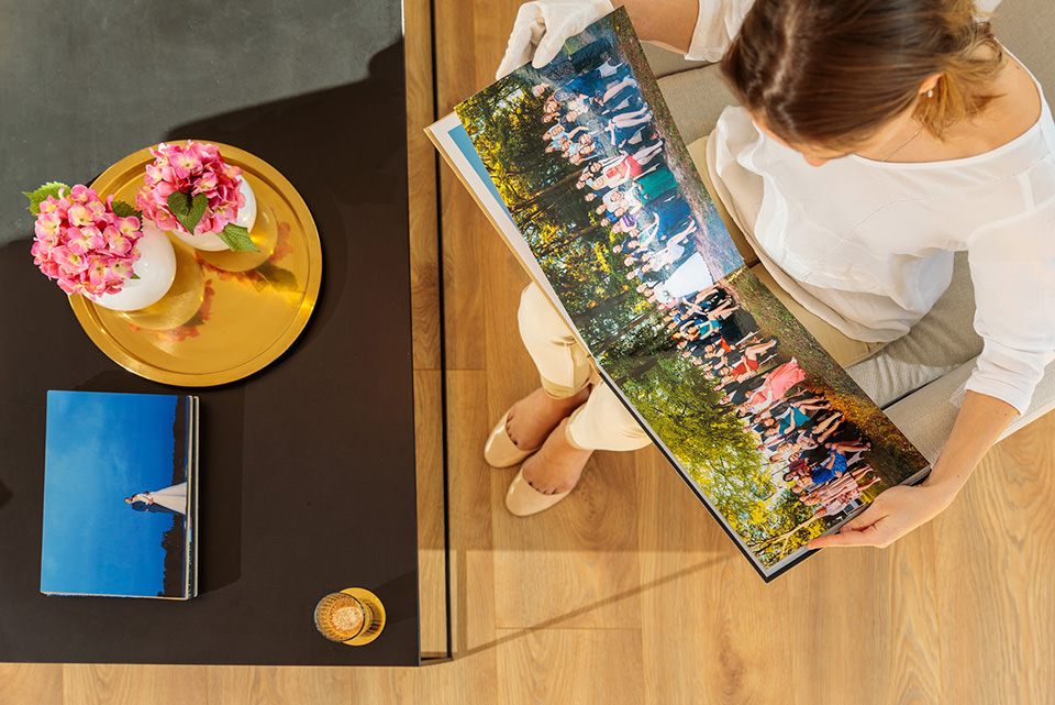 Gast guckt sich Gruppenbild als Panorama im Hochzeitsfotobuch an