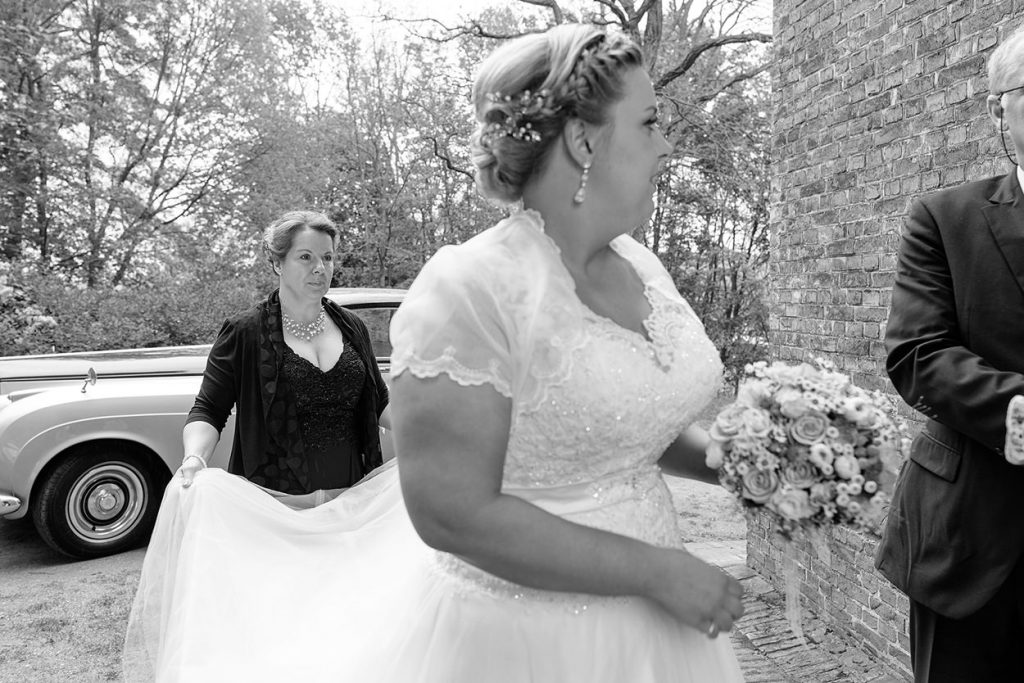 Die Mutter der Braut richtet nochmal das Kleid vor der Trauung