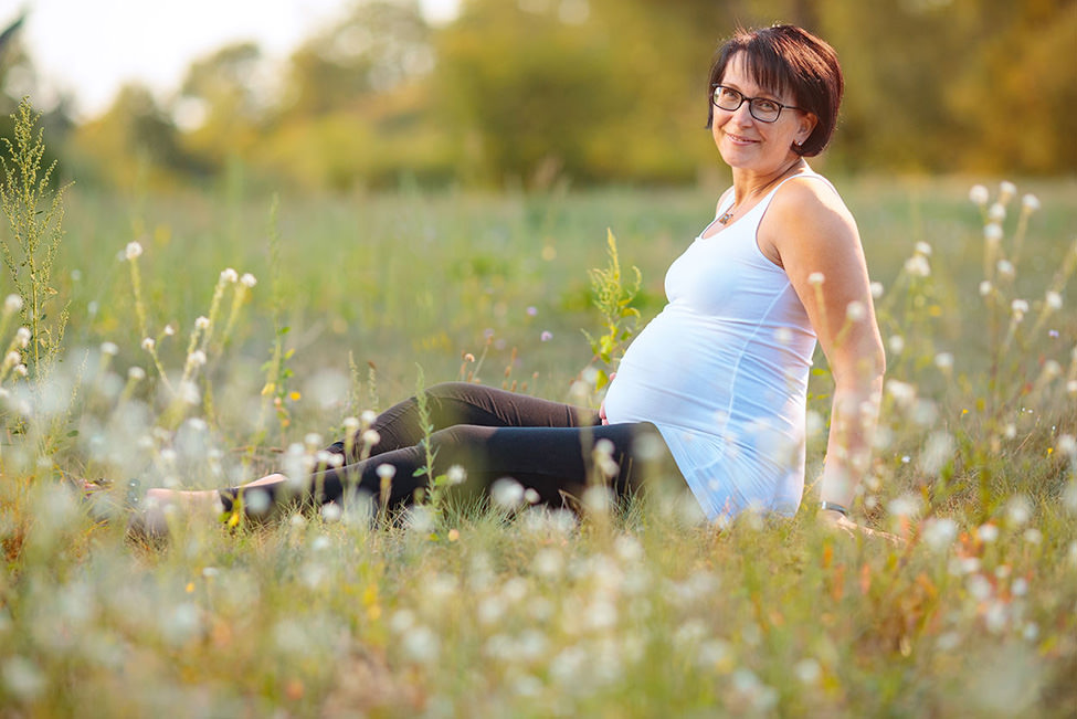 Schwangerschaftsfotos mit Babybauch auf Blumenwiese in Potsdam