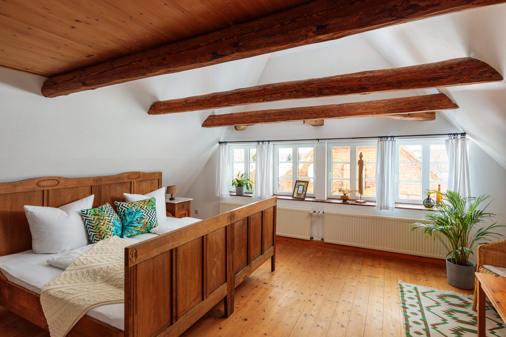 Schlafzimmer mit Doppelbett und Holzbalken in Traumferienhaus