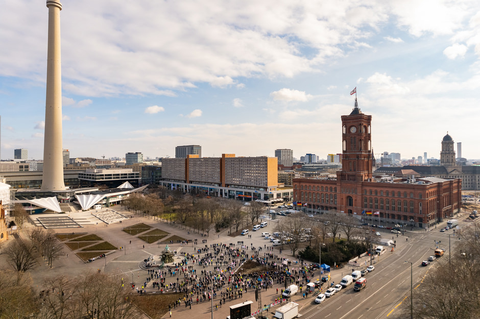 aerial photo of a crowd in front of the red capitol building of Berlin