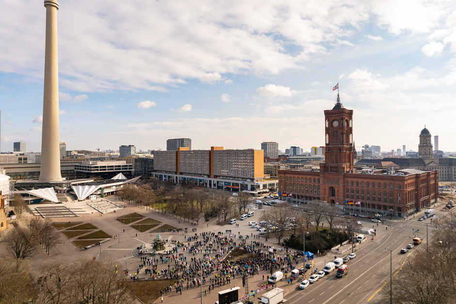 aerial photo of a crowd gathering in front of the red capitol building of Berlin