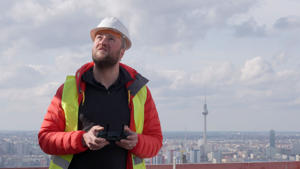 Drone pilot at construction site in Berlin during a flight with a quadrocopter